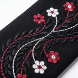 Full-length view of Black Crimson Flora Paisley Coat in Jet Black base with Crimson Pink, White, and Black thread embroidery
