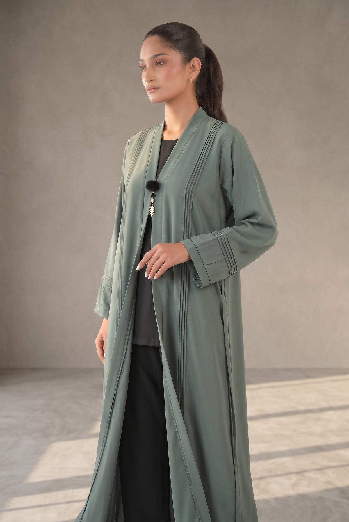 Side view of Sage Green Pleated Buckle Abaya showing black inner layer contrast